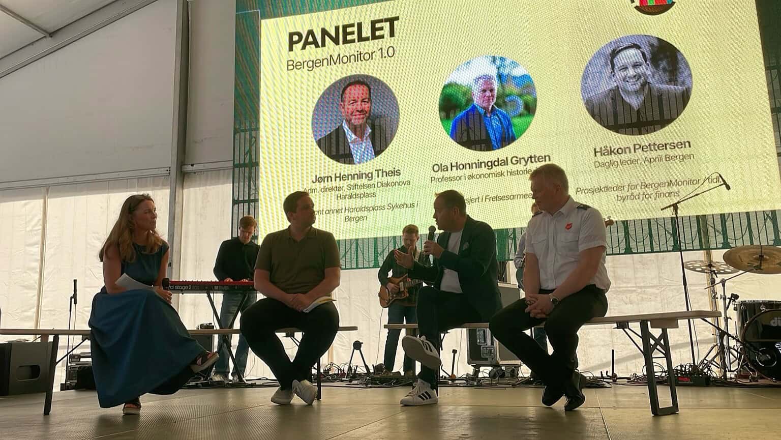 Panelsamtale på scenen under VM-gudstjenesten i Bergen, med lerret som viser panelet for BergenMonitor 1.0